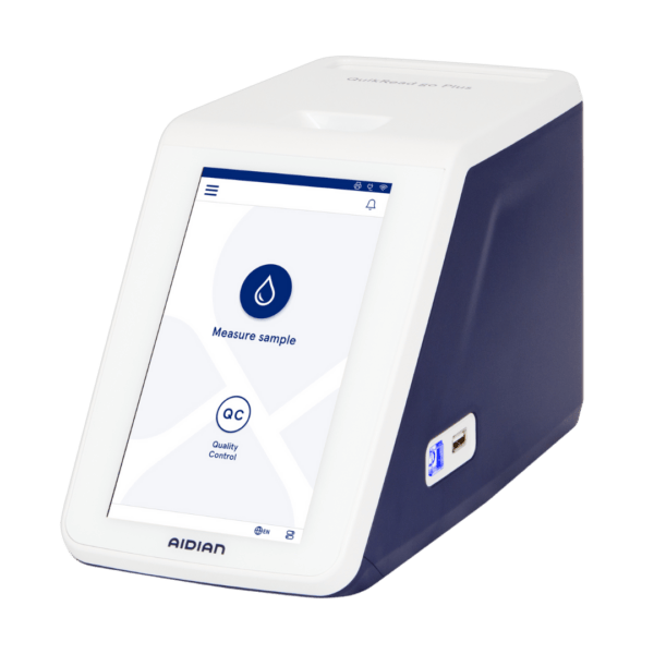 Aidian QuikRead go Plus, a compact automatic medical device with a touchscreen for sample analysis and quality control.